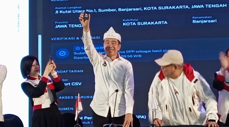 Joko Widodo (Jokowi) mengangkat kartu tanda anggota (KTA) Partai Solidaritas Indonesia (PSI)